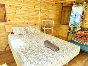 a bedroom with a bed in a log cabin at Beach Terrace Loft in Buen Hombre in Buen Hombre