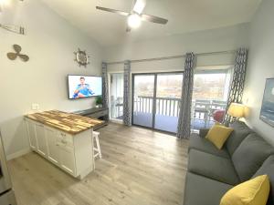 sala de estar con sofá y TV de pantalla plana en B Lakefront! Remodeled, Boat Slip, Patio Views, Pool, Boat Ramp, WIFI, en Osage Beach