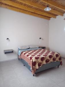 een bed in een witte kamer met een houten plafond bij La venecia in Guaymallen