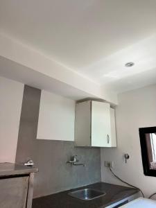 a kitchen with white cabinets and a sink at Hospedaje posada en Ezeiza in Ezeiza