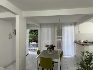 a kitchen and dining room with a table and chairs at Domaine de la villa d’orge in Vieux-Habitants