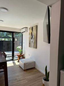 a living room with white walls and a white ottoman at Hospedaje posada en Ezeiza in Ezeiza