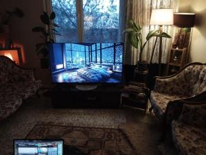 sala de estar con TV de pantalla plana y cama en Garden Village Home, en Ayvalık