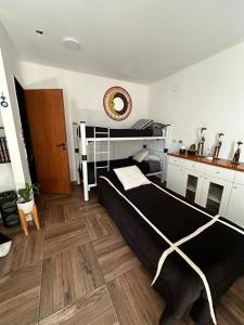 1 dormitorio con cama negra y suelo de madera en Hospedaje posada en Ezeiza en Ezeiza