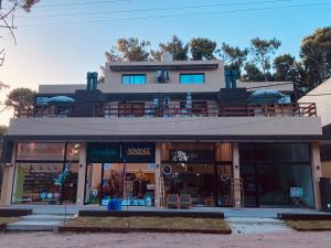 a store front of a building with tables and chairs at Ubatuba Lofts Mar Azul - depto 2 hab in Mar Azul +3 photos