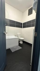 a bathroom with a toilet and a tub and a sink at Modern 2 Bed near Turf Moor Football Stadium, Parks, Canal and Lake in Burnley