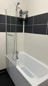 a bathroom with a shower and a white tub at Modern 2 Bed near Turf Moor Football Stadium, Parks, Canal and Lake in Burnley