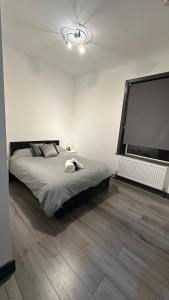 a bedroom with a large bed and a large screen at Modern 2 Bed near Turf Moor Football Stadium, Parks, Canal and Lake in Burnley