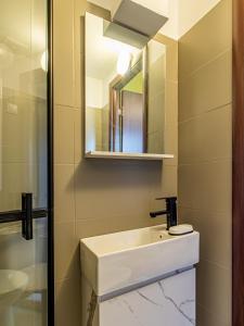 a bathroom with a white sink and a mirror at Vazov Loft - Central Sofia Studio in Sofia