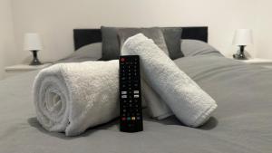 a remote control sitting on top of a bed at Modern 2 Bed near Turf Moor Football Stadium, Parks, Canal and Lake in Burnley