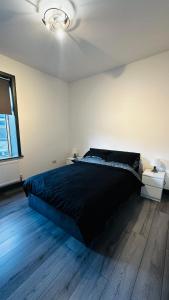 Un dormitorio con una gran cama negra y una ventana en Modern 2 Bed near Turf Moor Football Stadium, Parks, Canal and Lake en Burnley