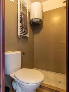 a bathroom with a white toilet and a light at Vazov Loft - Central Sofia Studio in Sofia