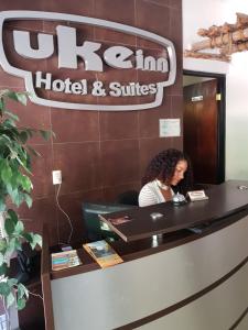 a woman sitting at a desk in a hotel and suites at Ukeinn centro in Tuxtla Gutiérrez