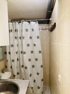 a bathroom with a shower curtain with black stars on it at Studio house near paris in Épinay-sur-Seine