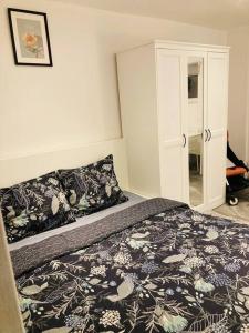 a bedroom with a bed with a black and white blanket at Studio house near paris in Épinay-sur-Seine