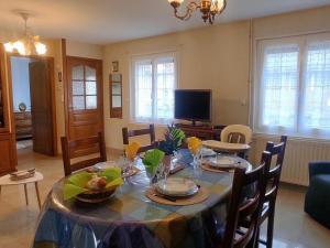 uma sala de jantar com uma mesa com cadeiras e uma televisão em Gîte Formerie, 3 pièces, 4 personnes - FR-1-526-45 em Grumesnil