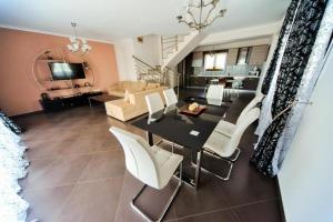 sala de estar con mesa de comedor y sillas blancas en Villas Hanioti, en Chaniotis