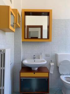 een badkamer met een wastafel, een toilet en een spiegel bij Pier’s House in Garbagnate Milanese