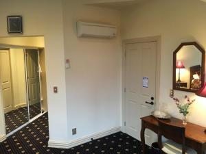 Cette chambre dispose d'un couloir avec une table et un miroir. dans l'établissement Fontainebleau Luxury B&B, à Hanmer Springs