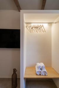 a room with a shelf with towels and a vase at Mountain Mini Suite in Áyioi Dhéka
