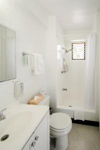ein weißes Bad mit einem WC und einem Waschbecken in der Unterkunft Stay Condominiums Waikiki in Honolulu