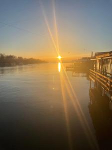 a sunset over a body of water with a dock at Stella Marina in Pržno