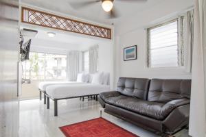 a living room with a couch and two beds at Stay Condominiums Waikiki in Honolulu