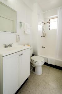 Baño blanco con aseo y lavamanos en Stay Condominiums Waikiki, en Honolulu