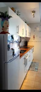a kitchen with white cabinets and a refrigerator at Appartamento Sol in Puerto del Rosario +25 photos