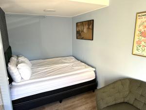 een kleine slaapkamer met een bed en een stoel bij Central studio apartment in Reykjavík