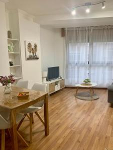 Una sala de estar con una mesa y un televisor. en Plaza America Home, en Vigo 33 fotos más
