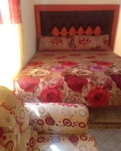 ein Bett mit roten Blumen darauf in einem Schlafzimmer in der Unterkunft 1 bdrm1 1 bath in Old Harbour