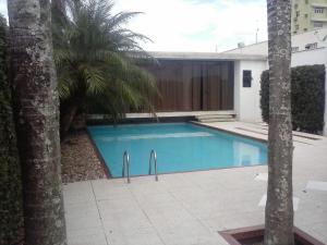 a swimming pool with palm trees next to a building at CORTESE HOTEL in Tatuí