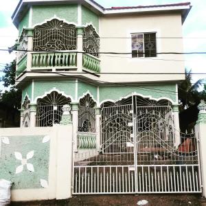 a green and white house with a gate at 1 bdrm1 1 bath in Old Harbour