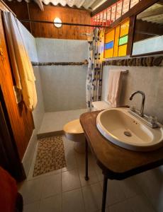 a bathroom with a sink and a shower and a toilet at Posada Turística Rocas De Cabo Marzo in Bahía Solano