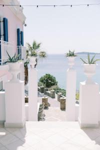 a view of the ocean from a house with white vases at Aneroussa Beach Hotel in Batsi
