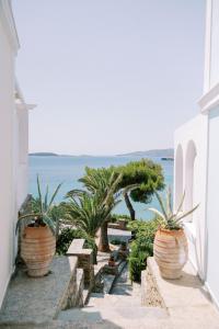 uma passagem com vasos de plantas e vista para o oceano em Aneroussa Beach Hotel em Batsi