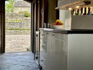 una cocina con una barra con un bol de fruta en Derbyshire Cottage for 4, 1 hour per day private pool use en Stanton in Peak