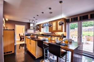 a kitchen with a large wooden island with black chairs at The Chase, Luxury Hot Tub Retreat, Pets Welcomed in Dipton