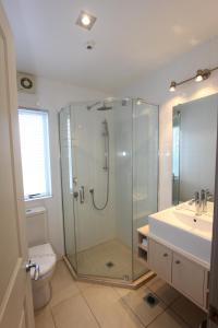 a bathroom with a shower and a toilet and a sink at Crow's Nest Apartments in Whitianga
