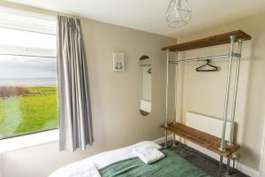 BessingbyにあるBEACHFRONT APARTMENT - Ground Floor Apartment with Sea Views, Next to the Beach, Bridlington, North Yorkshireのベッドと窓のある寝室