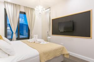 um quarto com uma cama e uma televisão de ecrã plano em Samstag Split em Split