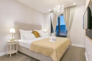 sypialnia z dużym łóżkiem i żyrandolem w obiekcie Samstag Split w Splicie