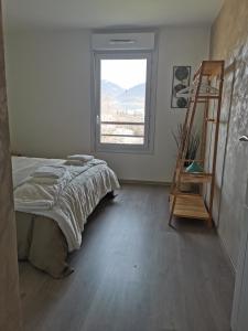 een slaapkamer met een bed, een ladder en een raam bij L'olympe in Albertville