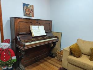 Uma boneca de Natal está ao lado de um piano. em Casa en Viña del Mar em Viña del Mar