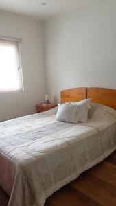 1 dormitorio con 1 cama blanca grande y ventana en Casa en Viña del Mar en Viña del Mar