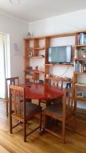 a dining room with a table and chairs and a tv at Casa en Viña del Mar in Viña del Mar