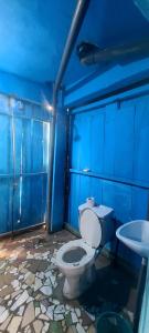 a blue bathroom with a toilet and a sink at Auberge chez M in Ganvié +62 photos