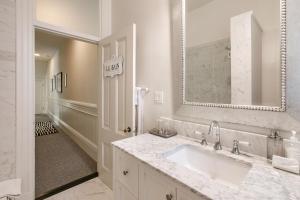 a white bathroom with a sink and a mirror at Pacific Heights Victorian Bedroom and Bathroom in San Francisco