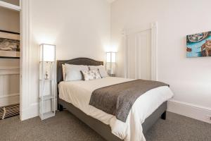 1 dormitorio con 1 cama grande y 2 lámparas en Pacific Heights Victorian Bedroom and Bathroom, en San Francisco